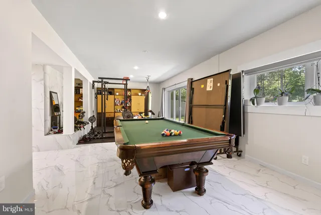 a room with furniture pool table and flat screen tv