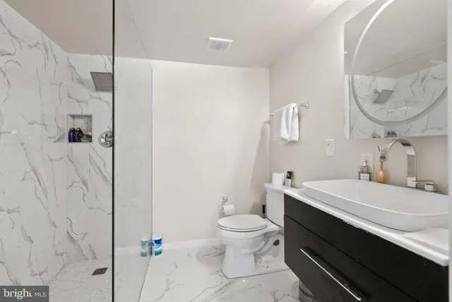 a bathroom with a sink a toilet and a mirror