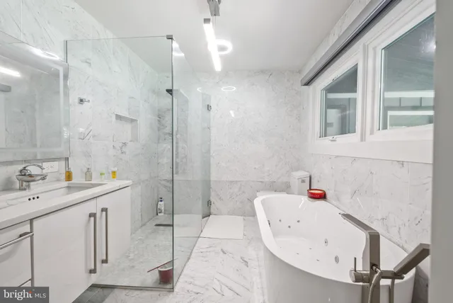 a bathroom with a tub sink and mirror