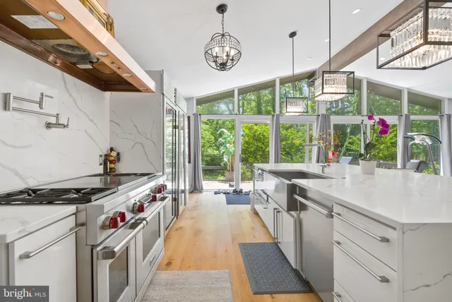 a kitchen filled with stainless steel appliances granite countertop a stove a sink and a refrigerator