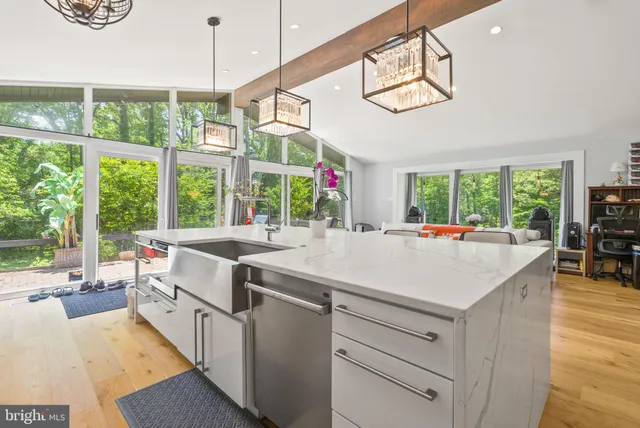 a open kitchen with stainless steel appliances granite countertop a stove and a large window