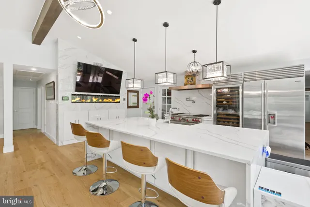 a kitchen with a sink a counter and chairs