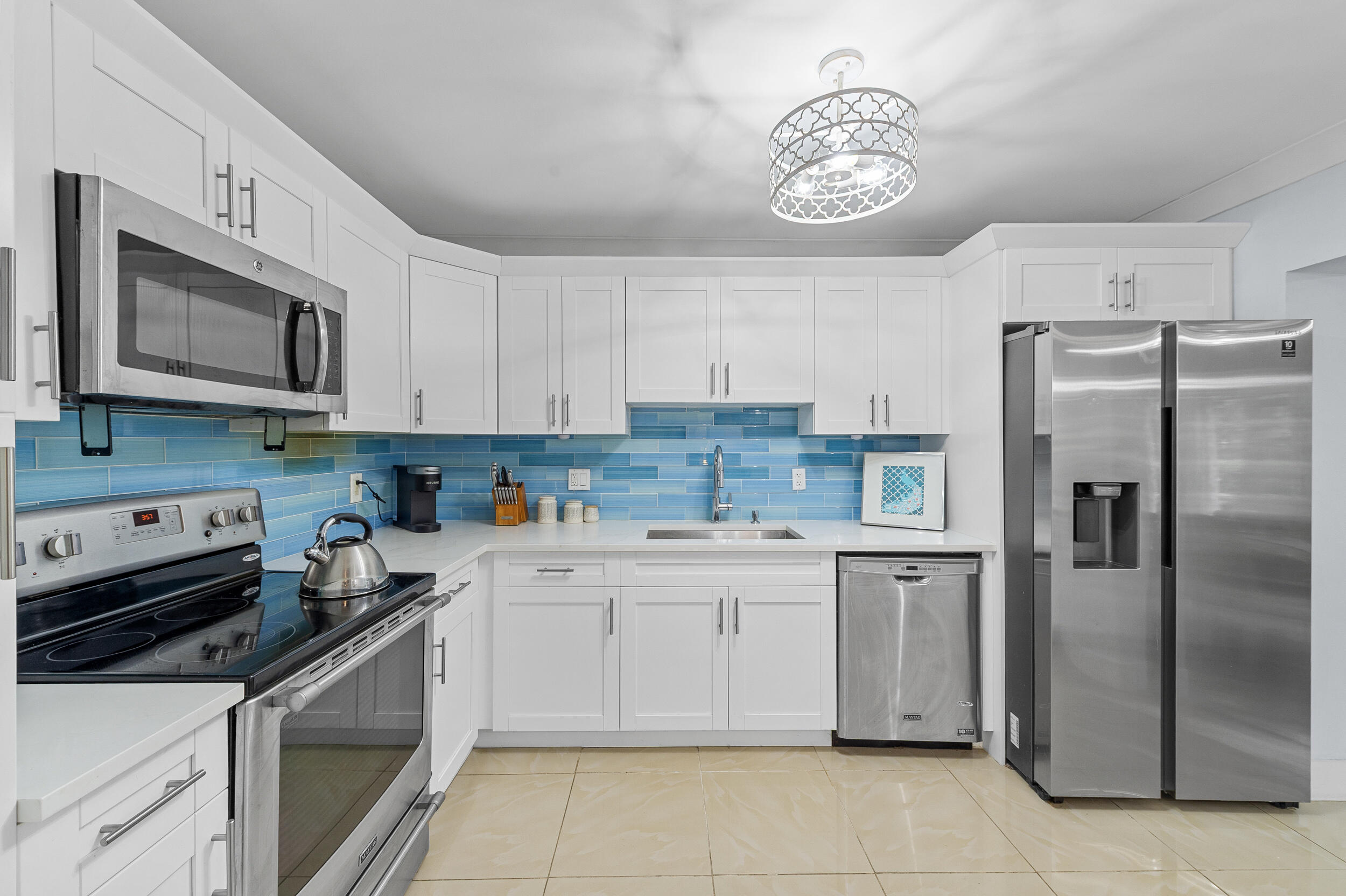 a kitchen with stainless steel appliances granite countertop a refrigerator sink and stove