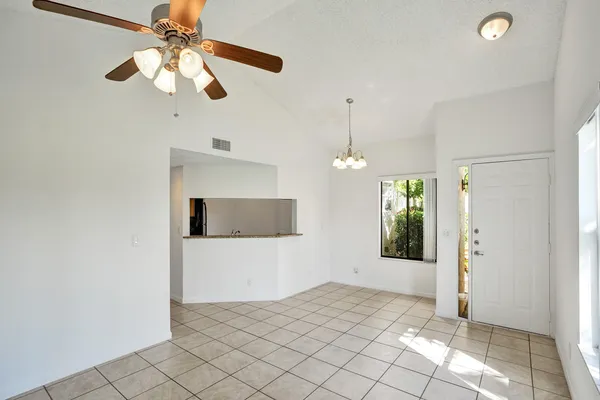 a view of a livingroom with a chandelier fan and windows