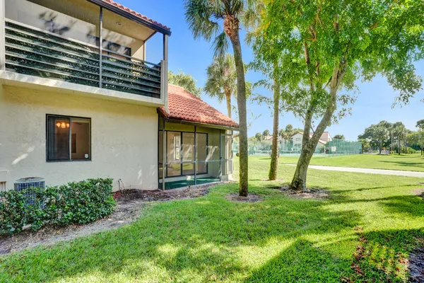 a view of a house with a backyard and a tree