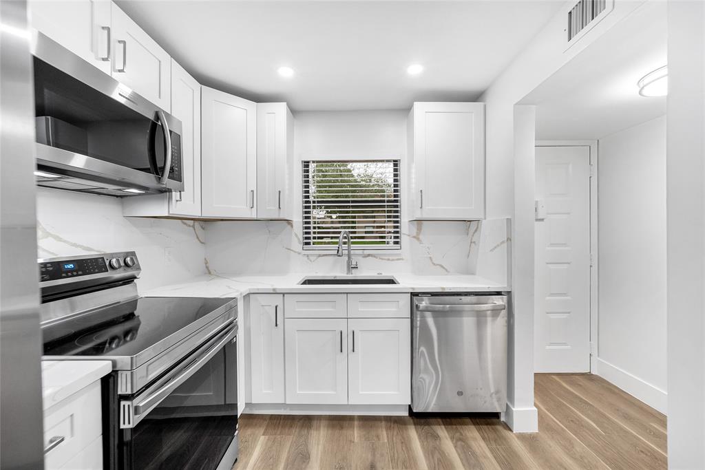 a kitchen with stainless steel appliances a stove microwave and sink