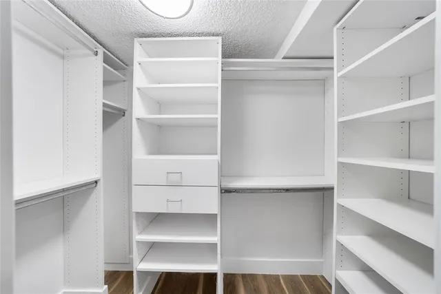 a view of walk in closet with empty racks