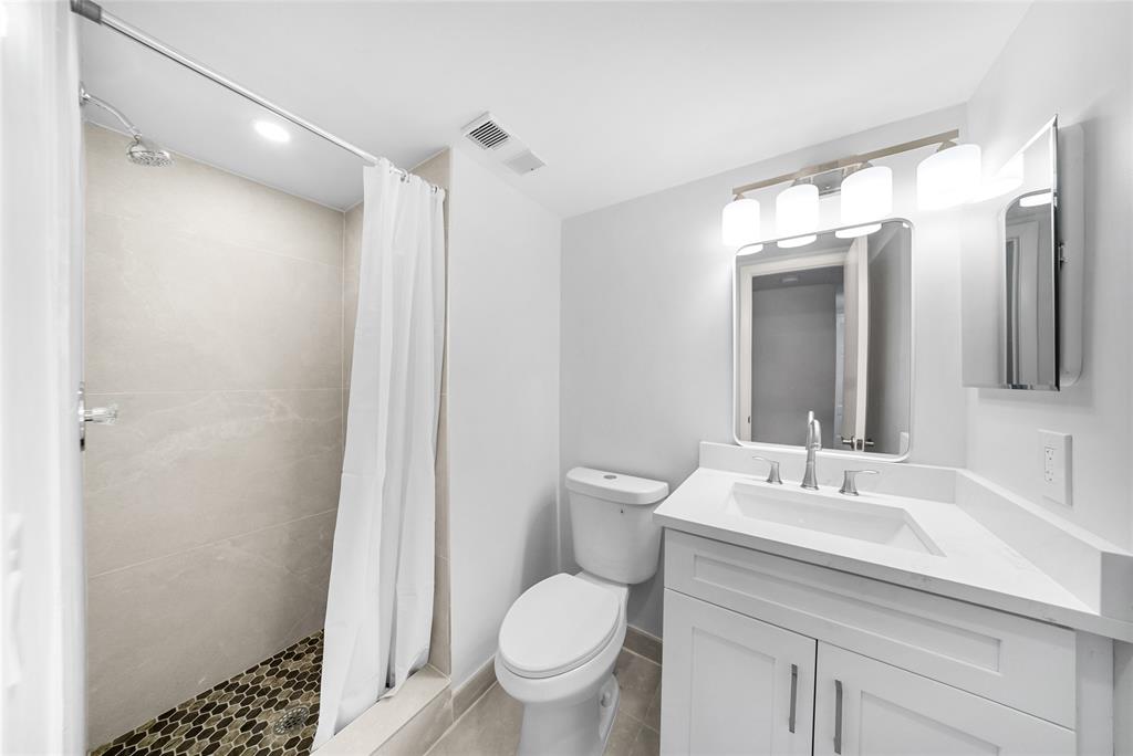 21905 Lake Forest Circle, Unit 101 Boca Raton, FL 33433 - Photo 12 of 23 a bathroom with a granite countertop sink toilet and shower