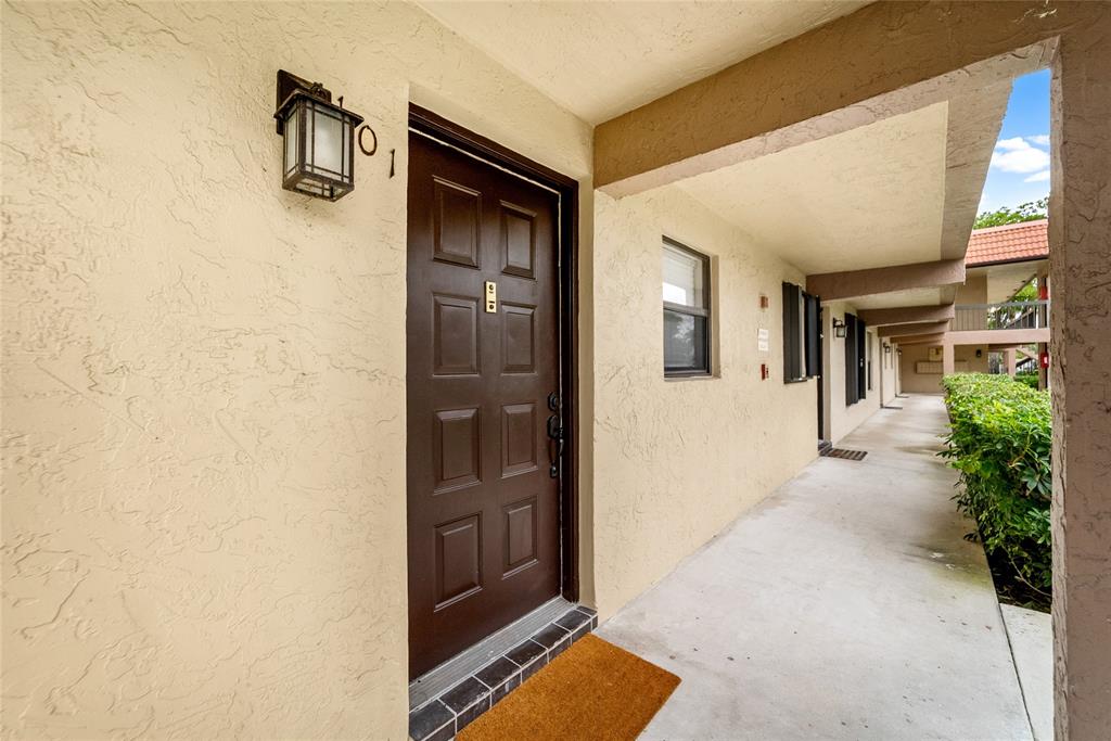 21905 Lake Forest Circle, Unit 101 Boca Raton, FL 33433 - Photo 19 of 23 a view of a hallway with wooden floor and a living room