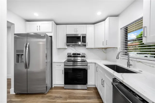 a kitchen with a stove sink and refrigerator