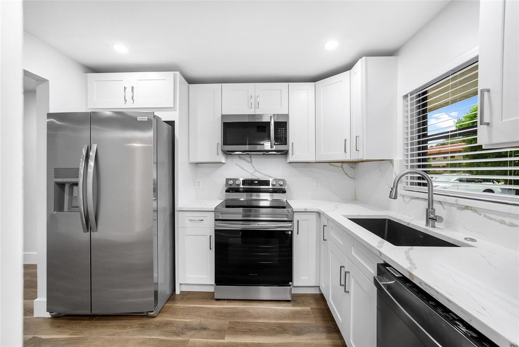21905 Lake Forest Circle, Unit 101 Boca Raton, FL 33433 - Photo 7 of 23 a kitchen with a stove sink and refrigerator