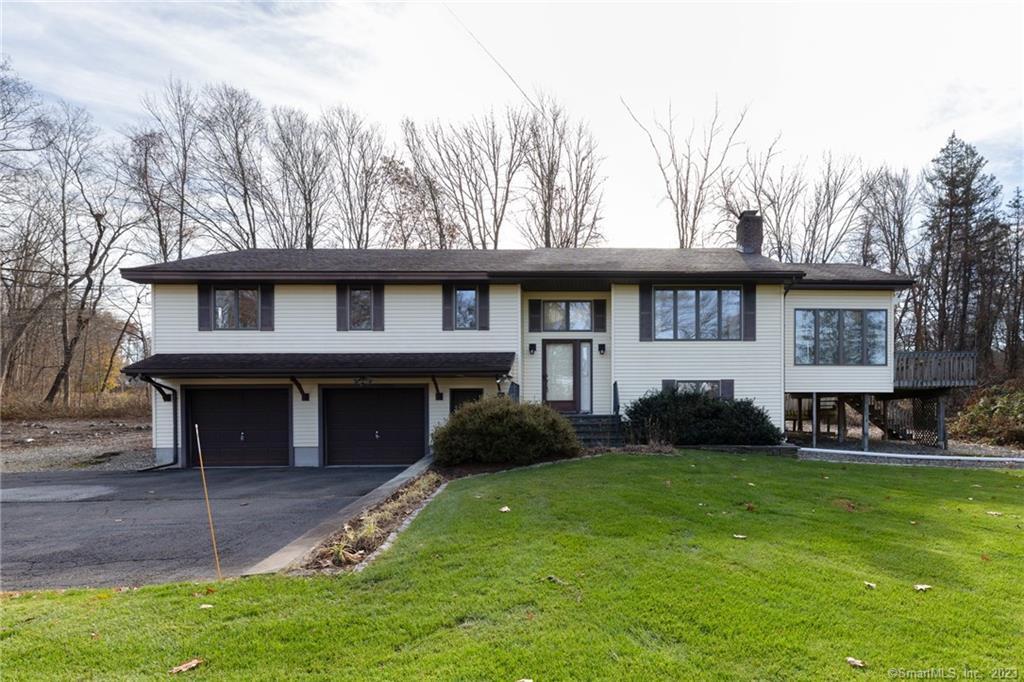 a view of a house with a yard and sitting area