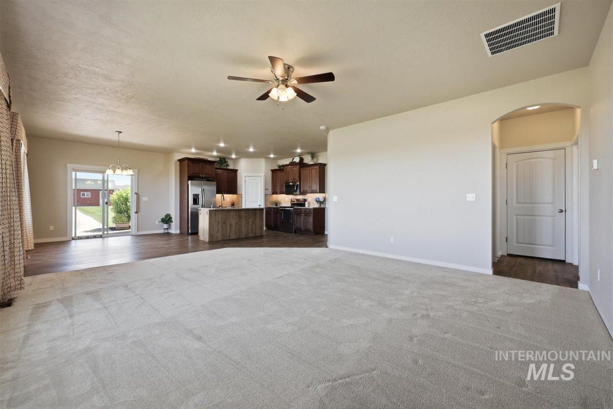 13496 Hockberger Ranch Road Caldwell, ID 83607 - Photo 19 of 40 Open-concept living space featuring light-toned carpeting and wood-finish flooring