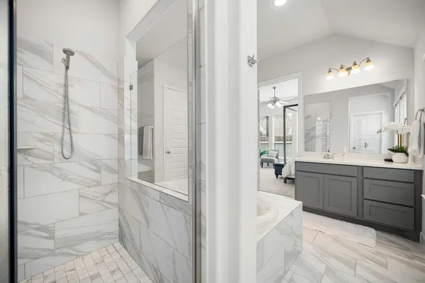 a spacious bathroom with a double vanity sink a mirror a bathtub and shower