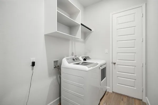 a utility room with cabinets washer and dryer
