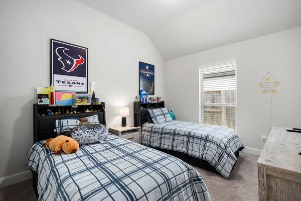 a bedroom with two beds and a window