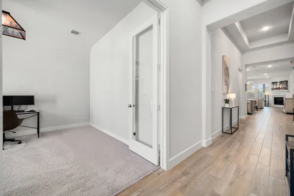 a view of a hallway with wooden floor table and chairs