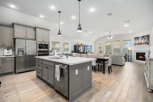 a large kitchen with stainless steel appliances kitchen island granite countertop a large center island and a refrigerator
