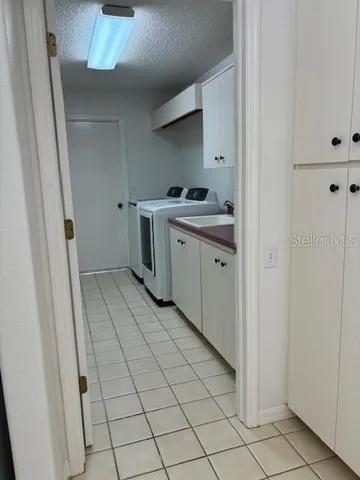 a room with washing machine and cabinets