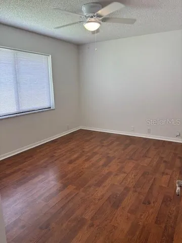 a view of an empty room with wooden floor