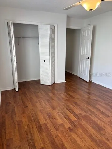 an empty room with wooden floor and closet area