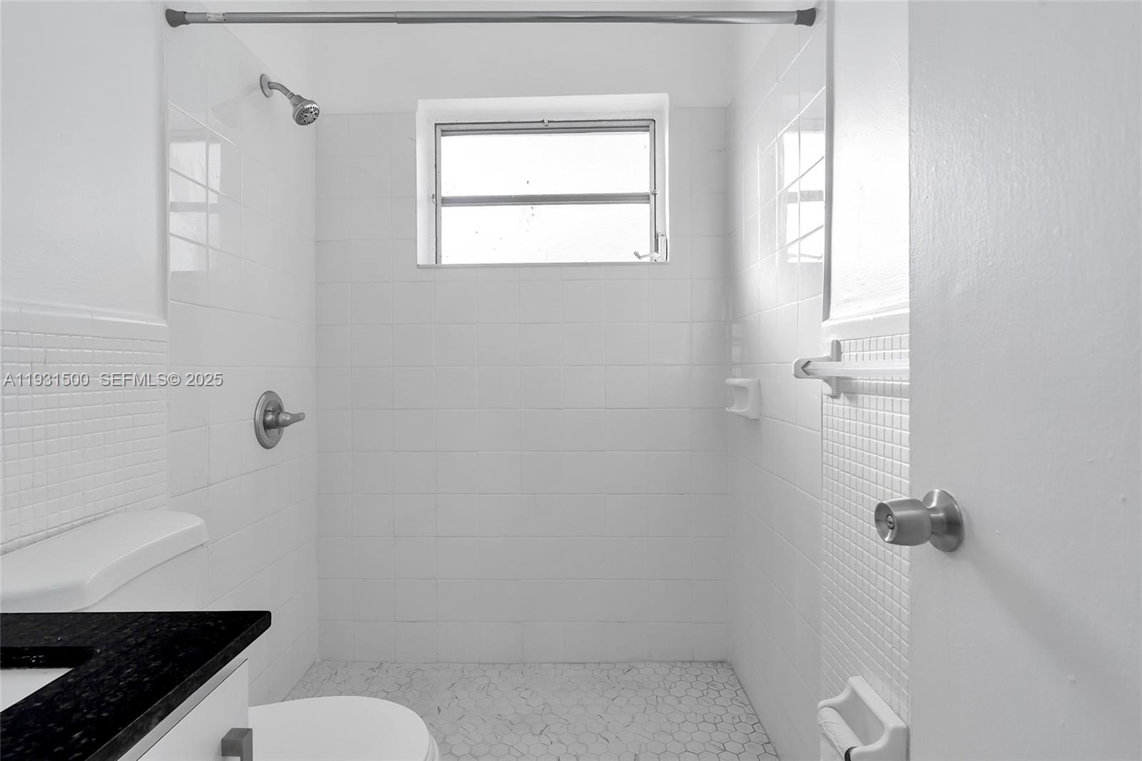 644 Southwest 10th Street, Unit 5 Miami, FL 33130 - Photo 17 of 26 a bathroom with a granite countertop toilet a sink and shower