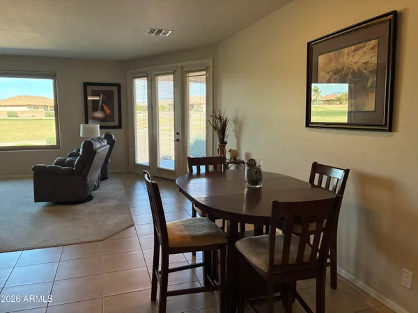 a kitchen with stainless steel appliances a refrigerator a stove a sink a dining table and chairs