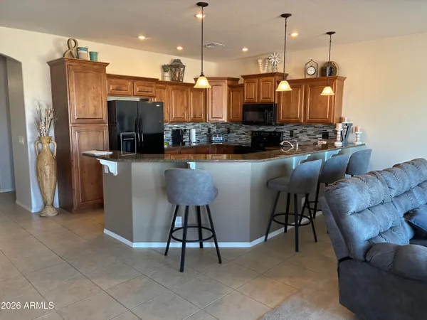a living room with couches and kitchen view with wooden floor