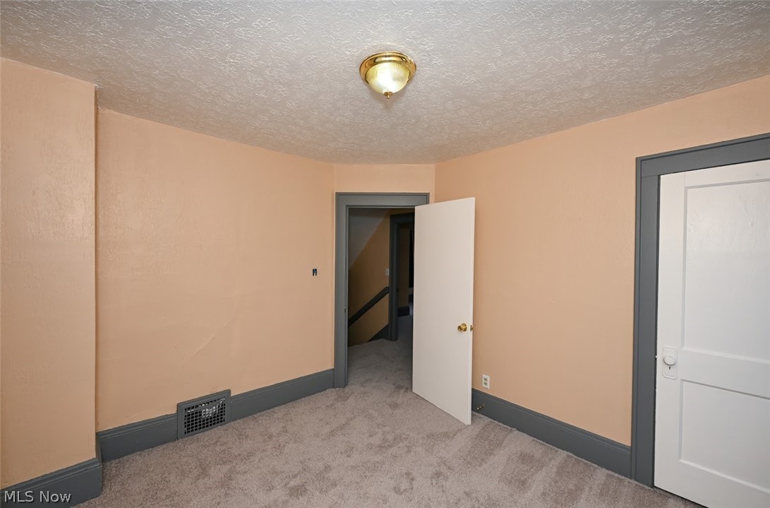 77 West Mildred Avenue Akron, OH 44310 - Photo 25 of 40 Spare room featuring carpet floors and a textured ceiling