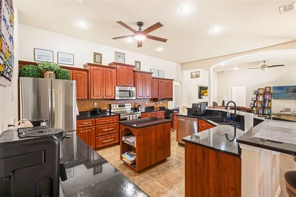 a kitchen with stainless steel appliances granite countertop a stove a sink dishwasher and a refrigerator
