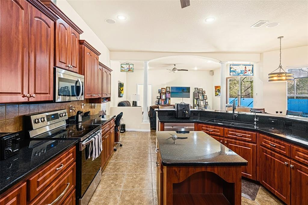 10288 Ridge Top Loop Weeki Wachee, FL 34613 - Photo 13 of 61 a kitchen with stainless steel appliances a sink stove and cabinets