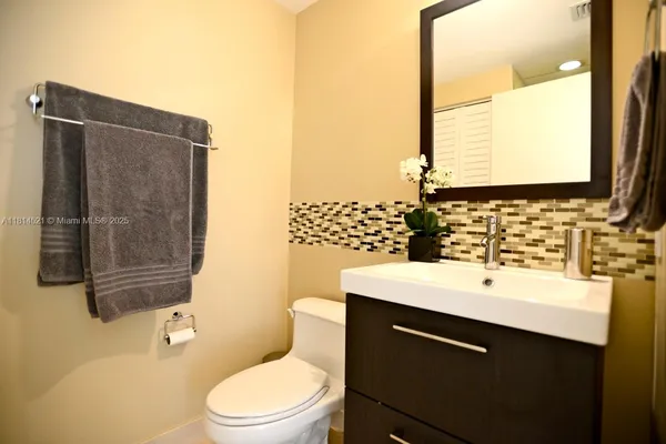 a bathroom with a sink a toilet and mirror