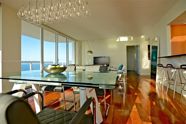 a kitchen with stainless steel appliances granite countertop a table chairs in it and wooden floors