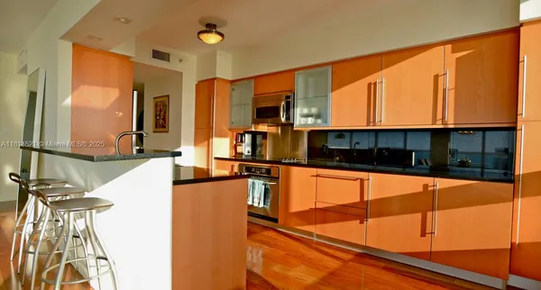 a kitchen with stainless steel appliances a sink and a large window