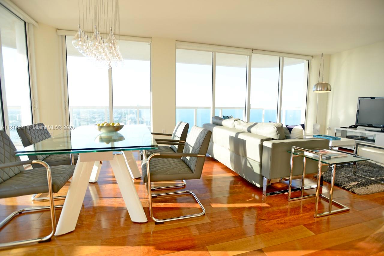 6365 Collins Avenue, Unit 3908 Miami Beach, FL 33141 - Photo 5 of 17 a view of a dining room with furniture water view and large windows