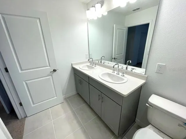 a bathroom with a sink toilet and mirror