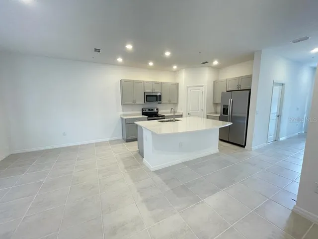 a large kitchen with a stove a refrigerator and a sink