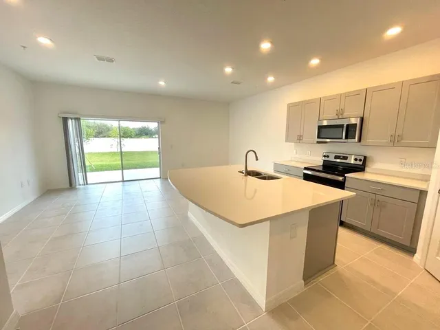 a kitchen with a sink a counter top space cabinets and stainless steel appliances