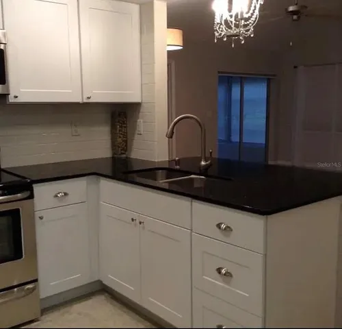 a kitchen with stainless steel appliances granite countertop a refrigerator a stove and a microwave