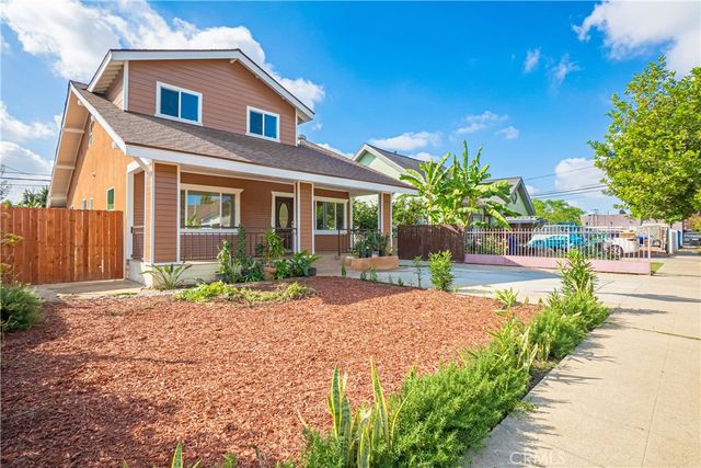 a front view of a house with a yard and potted plants