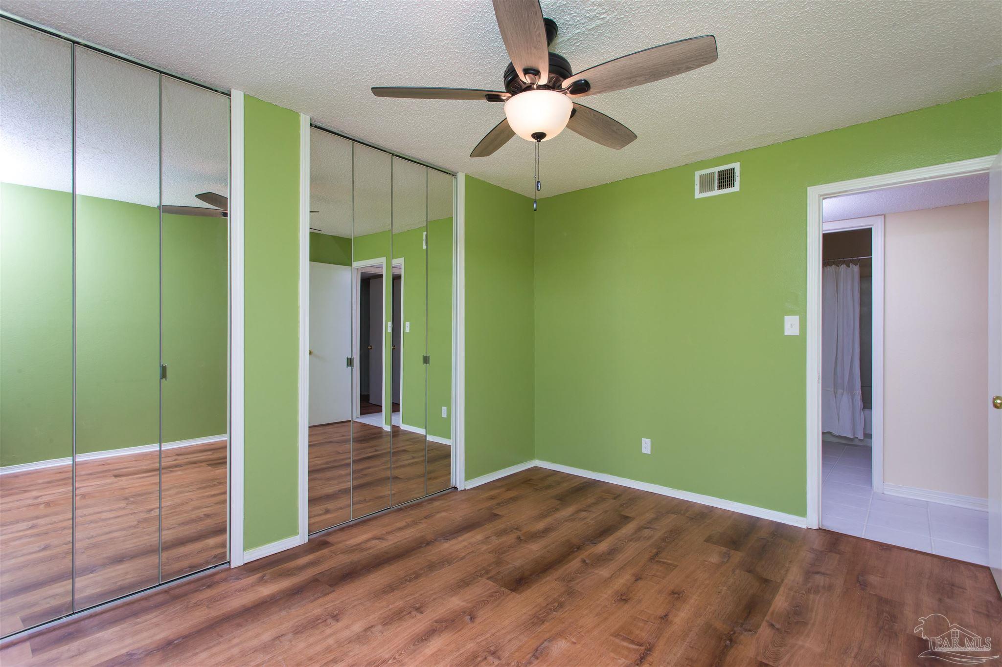 2299 Scenic Highway, Unit R10 Pensacola, FL 32503 - Photo 16 of 31 a view of a room with wooden floor and ceiling fan