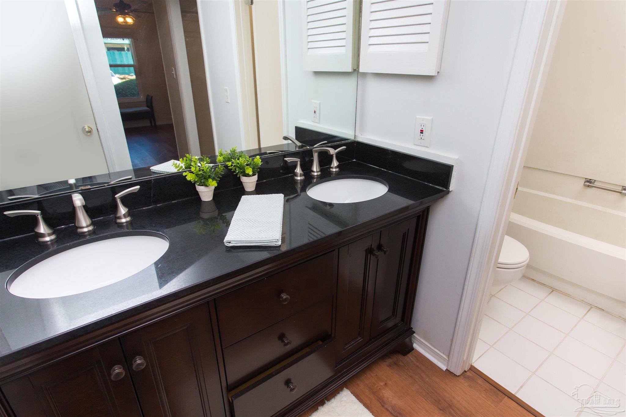 2299 Scenic Highway, Unit R10 Pensacola, FL 32503 - Photo 18 of 31 a bathroom with a granite countertop sink and a mirror