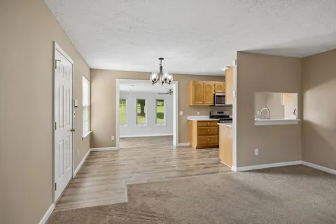 an empty room with a chandelier fan and closet area