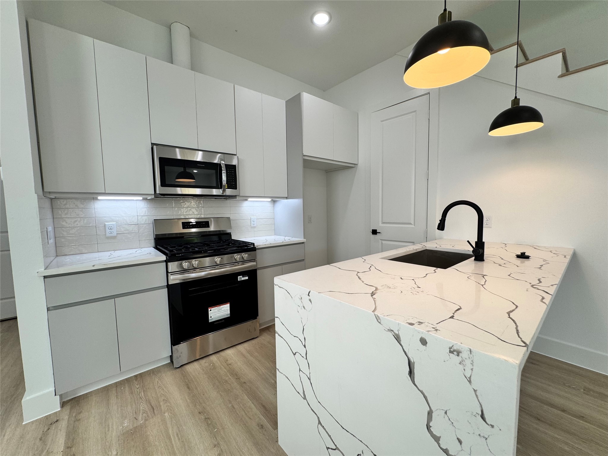 1506 Griffin Street Houston, TX 77009 - Photo 5 of 16 a kitchen with stainless steel appliances granite countertop a stove a sink and a microwave