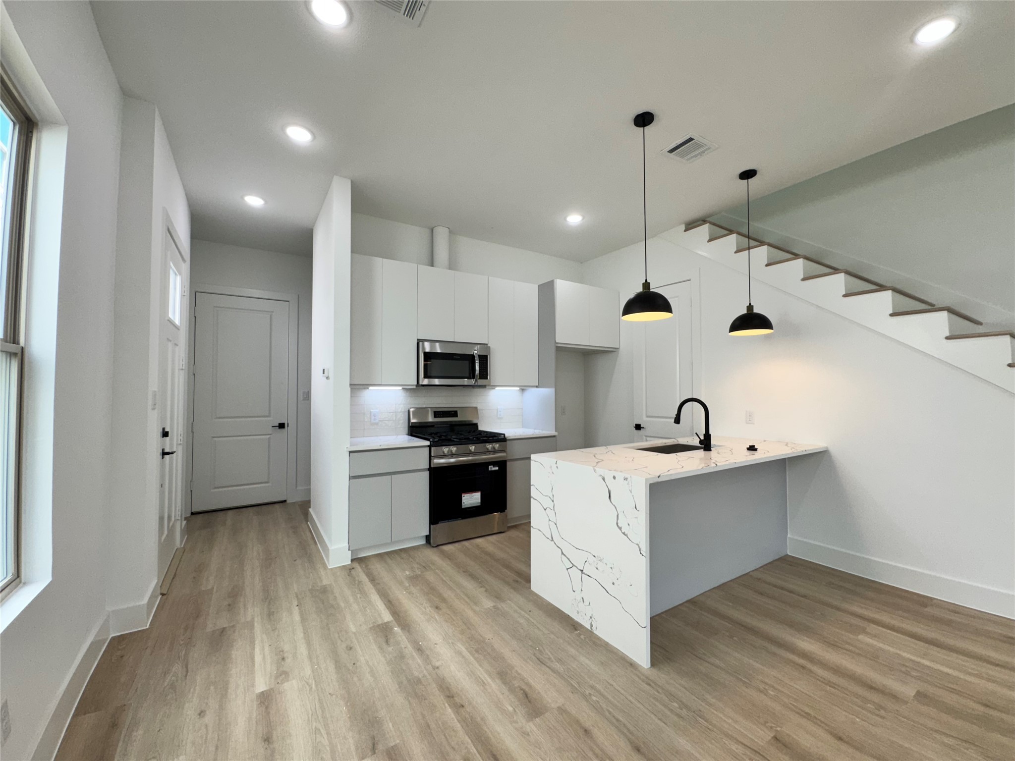 1506 Griffin Street Houston, TX 77009 - Photo 8 of 16 a kitchen with cabinets wooden floor and stainless steel appliances