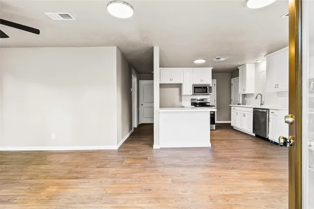 a view of a kitchen with kitchen island and stainless steel appliances