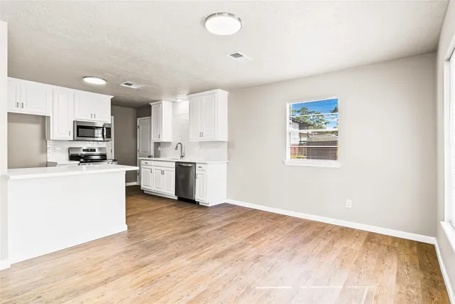 a kitchen with stainless steel appliances a refrigerator sink and cabinets