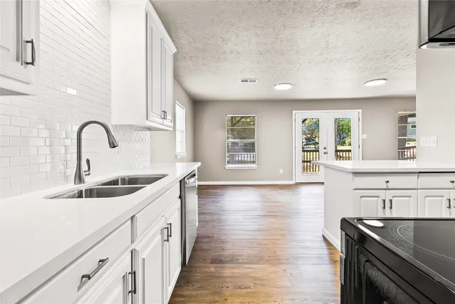 a view of a kitchen with wooden floor and electronic appliances