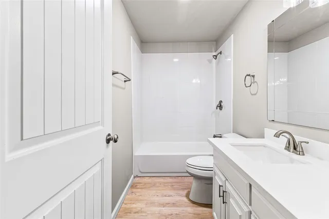a bathroom with a sink a toilet and a large mirror