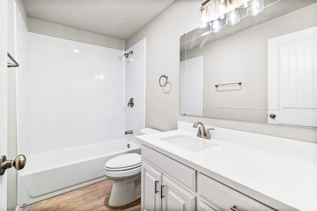 a bedroom with a large bed and a potted plant